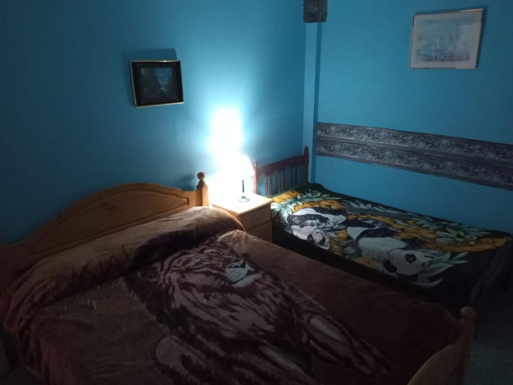 a room with two beds in a blue room at Departamento 2 ambientes PB a metros del mar in Mar de Ajó