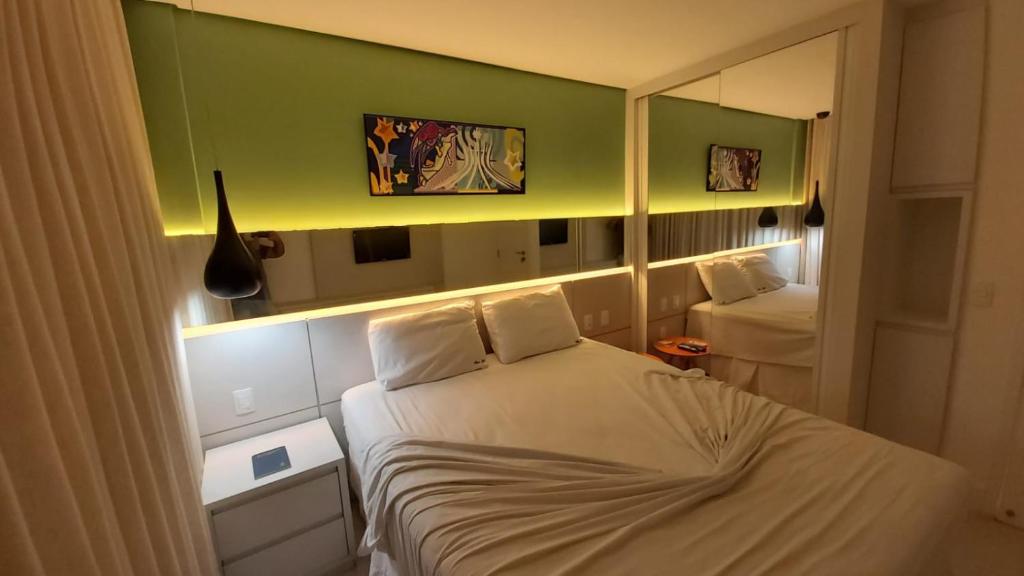 Bicalho Flat beira mar - Hotel PontaNegraBeach في ناتال: غرفة نوم صغيرة مع سرير ومرآة