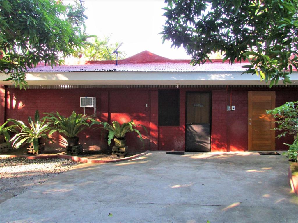 a red house with a driveway in front of it at Felipa Beach Residence - Ilang Ilang in Dumaguete