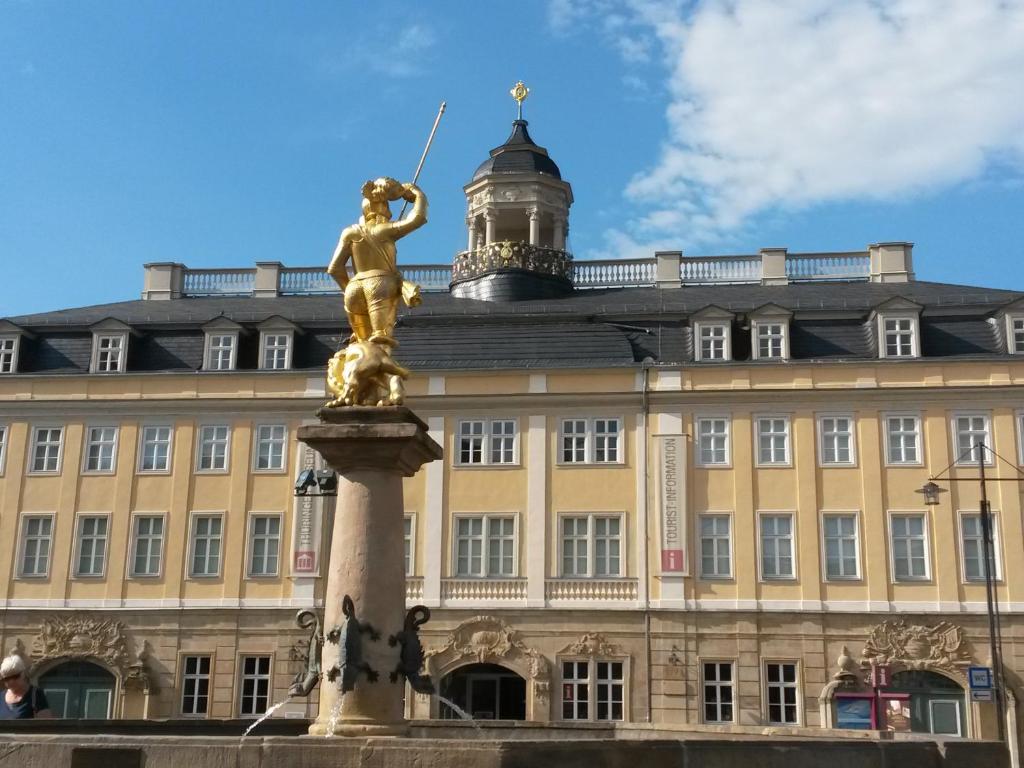 una statua di fronte a un grande edificio di Villa Weitblick a Eisenach
