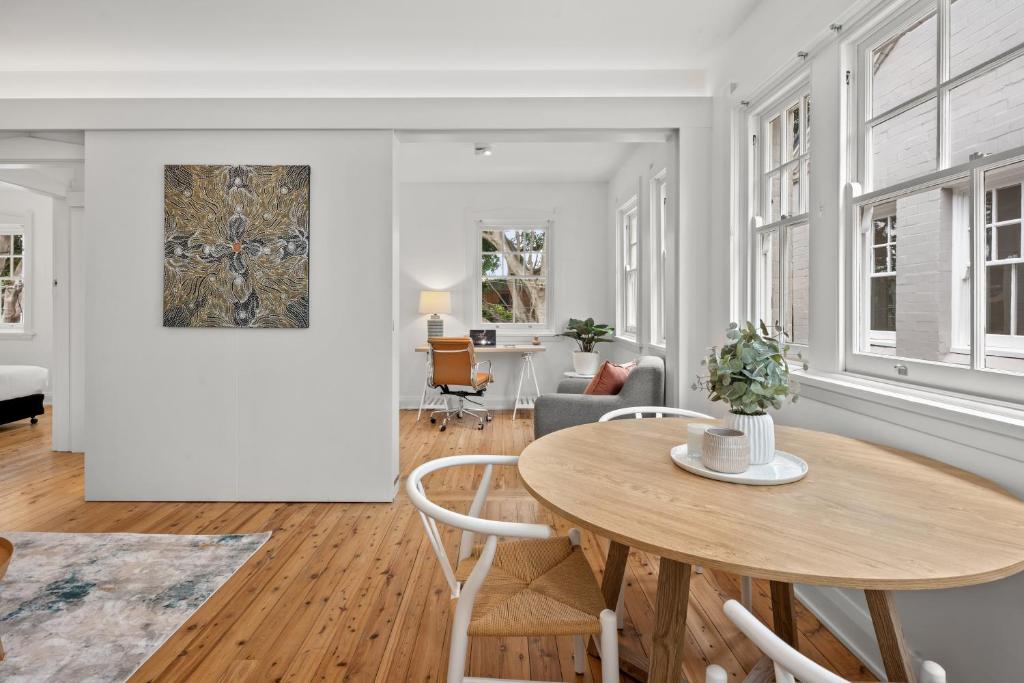 una sala de estar con una mesa y sillas en Mulwarree Avenue Apartments by Urban Rest, en Sídney