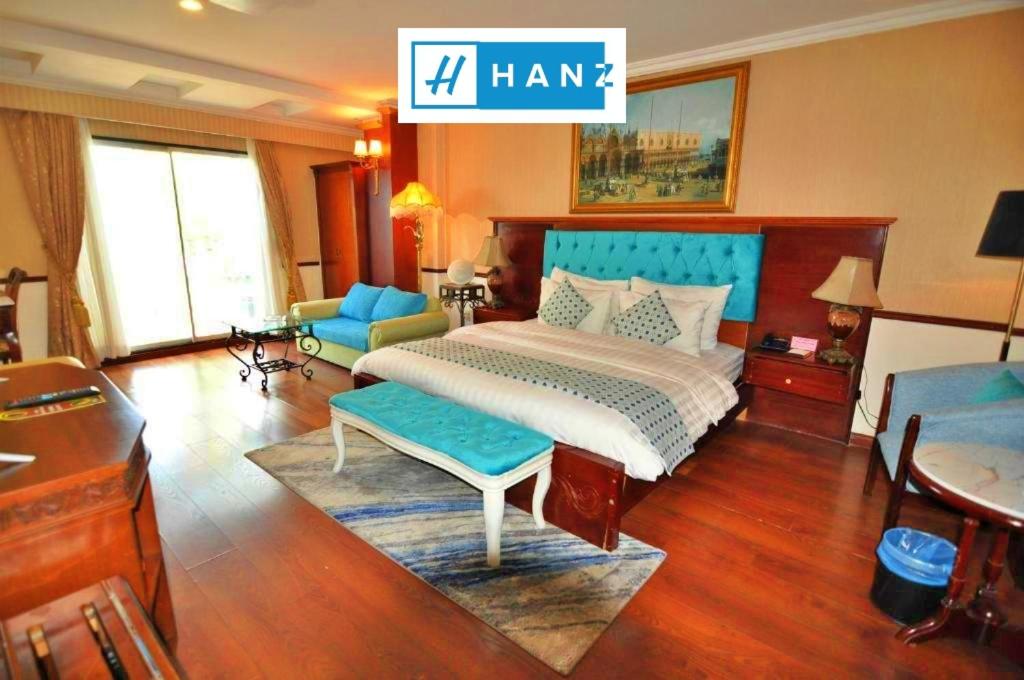 een slaapkamer met een bed met een blauw hoofdeinde bij Hoa Huong Duong Hotel Saigon in Ho Chi Minh-stad