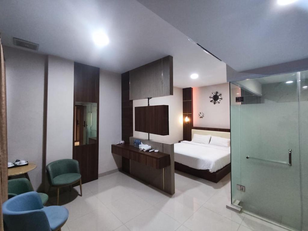 a hotel room with a bed and a bathroom at Hotel Morena Batam in Batam Center