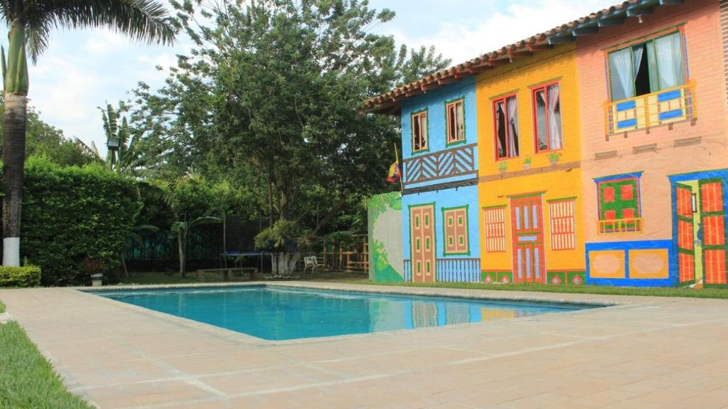 una casa con piscina frente a un edificio en Hotel Cabañas De Rozo, en Rozo