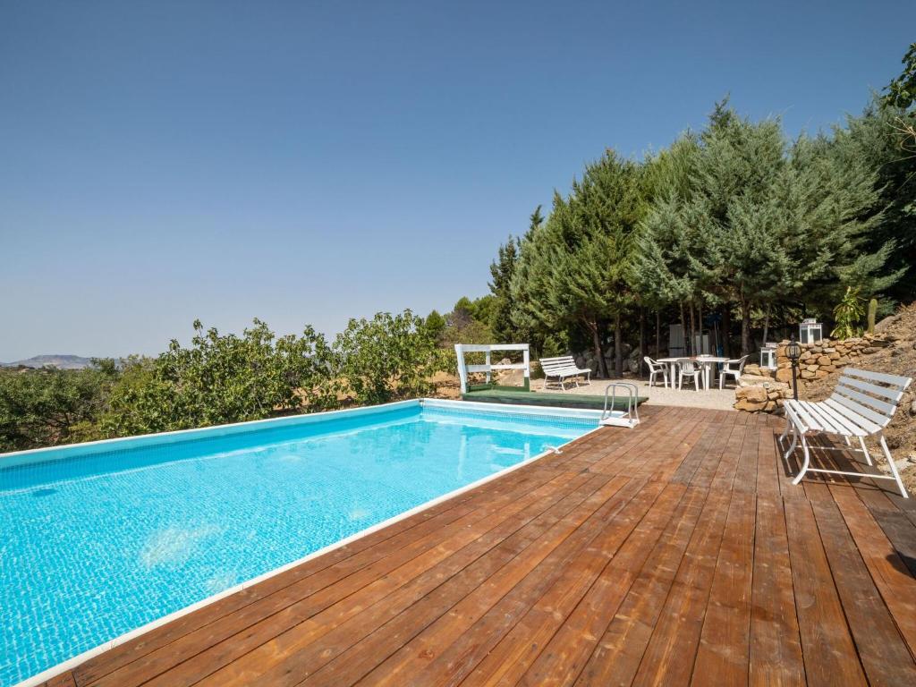 a swimming pool on a wooden deck next to a swimming pool at Belvilla by OYO Modern villa in Nissoria with pool in Nissoria