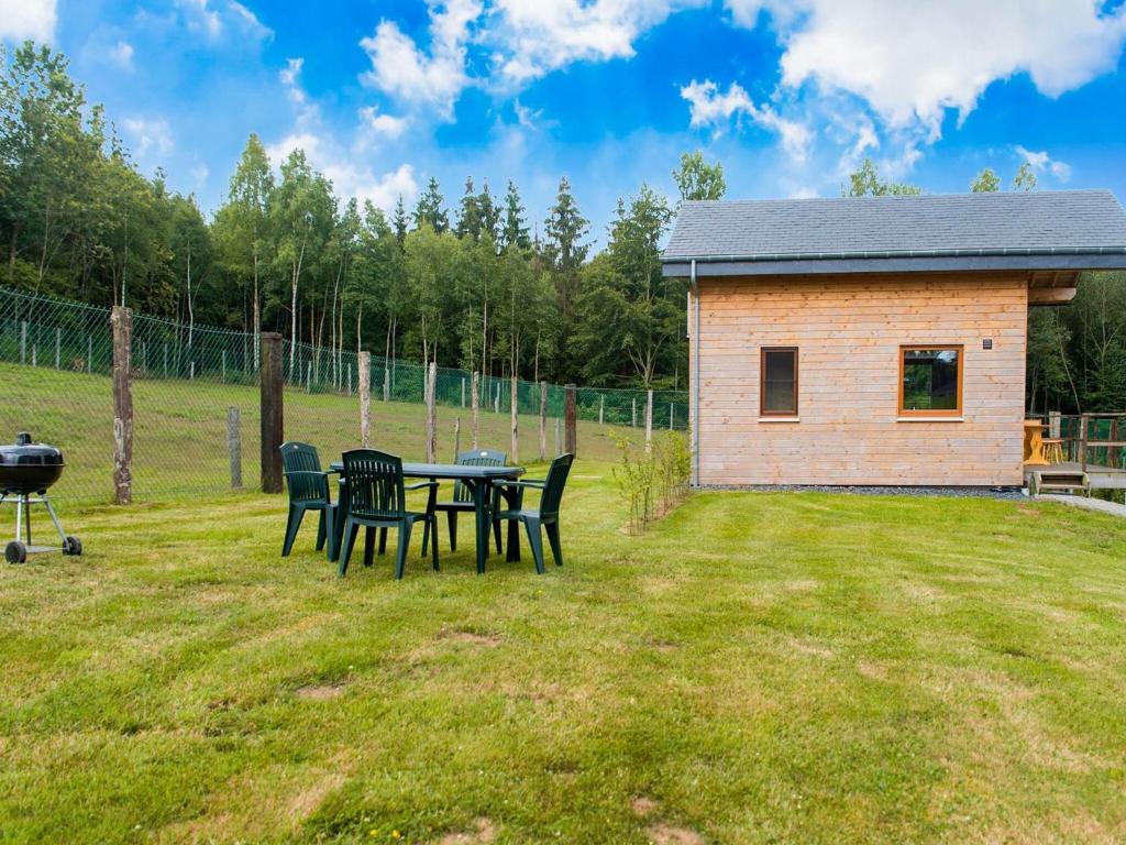 una mesa de picnic con sillas y una parrilla en un patio en Quaint Chalet in Rogery with Garden Terrace and Barbecue, en Rogery