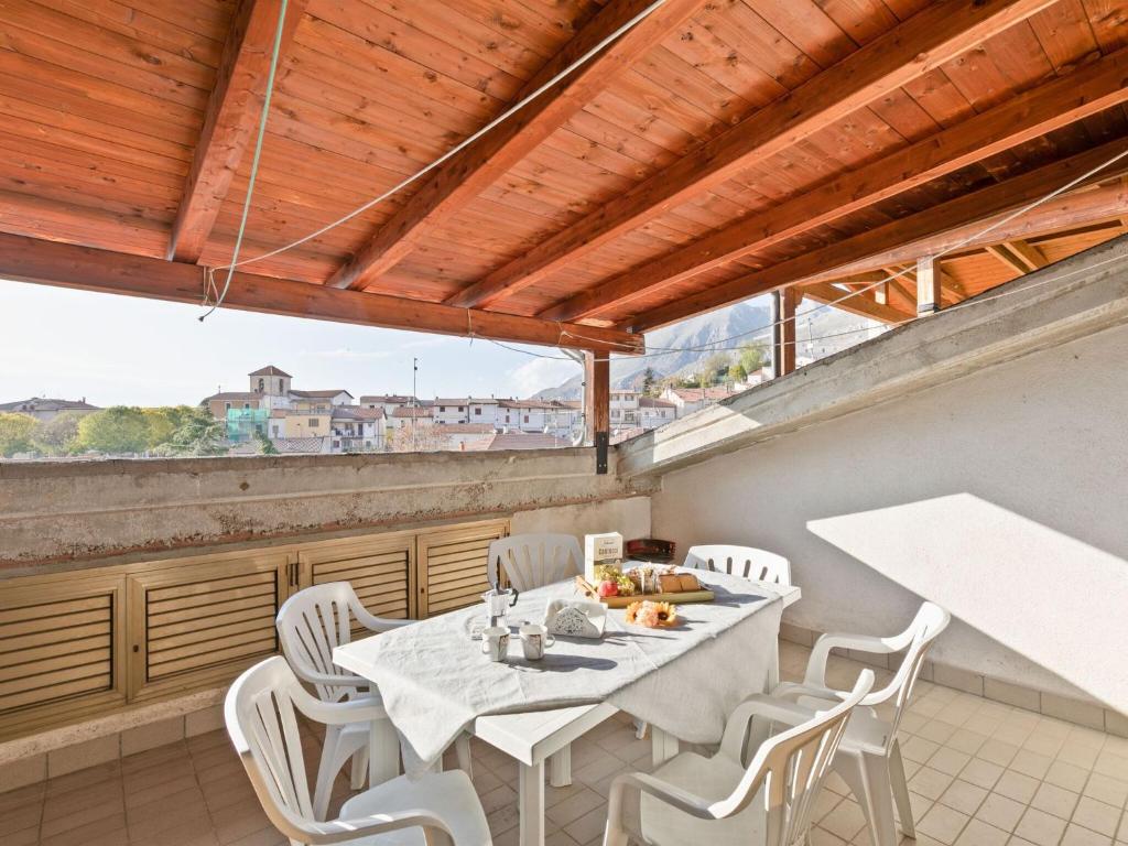 ein Esszimmer mit einem Tisch und weißen Stühlen in der Unterkunft Belvilla by OYO Sirente House in Aielli