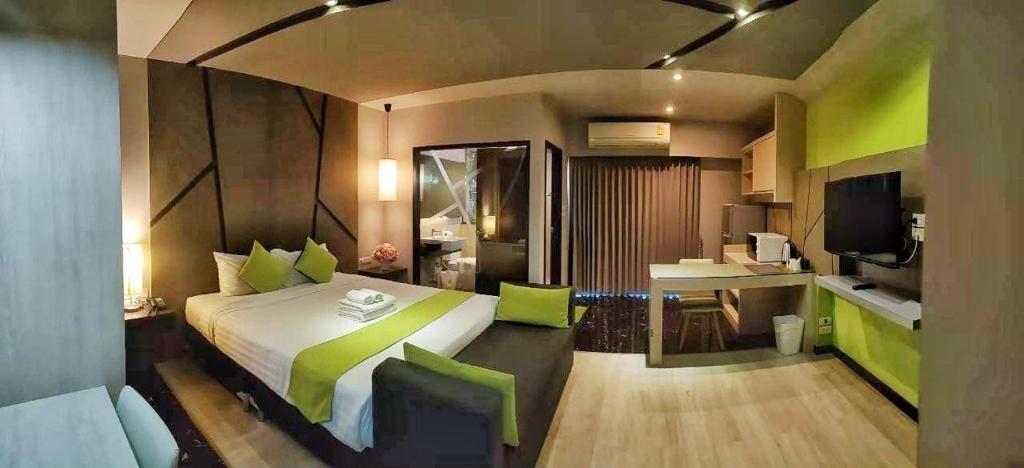 a bedroom with a large bed with green accents at 3Season in Chiang Mai