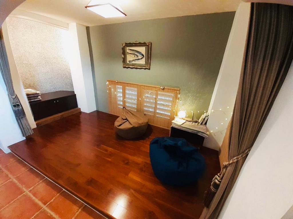 a living room with wood floors and a blue ottoman at Bridge12th B&amp;B in Yanliau