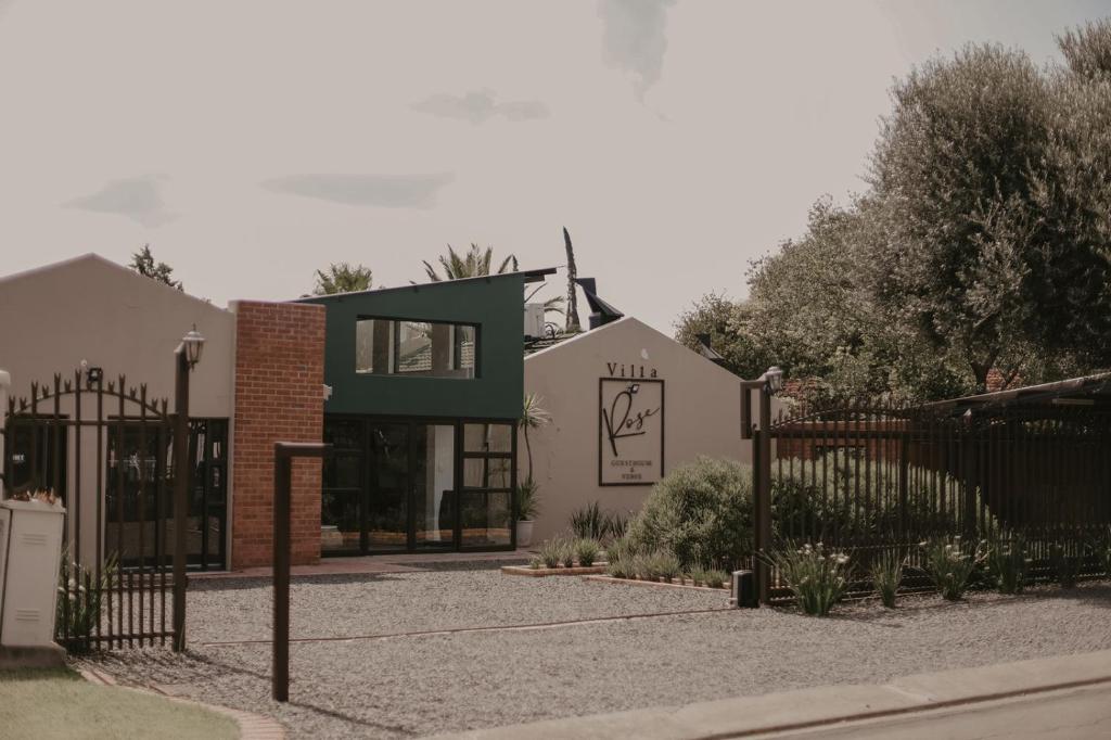 a house with a gate and a building at Villa Rose Guesthouse & Venue in Bloemfontein