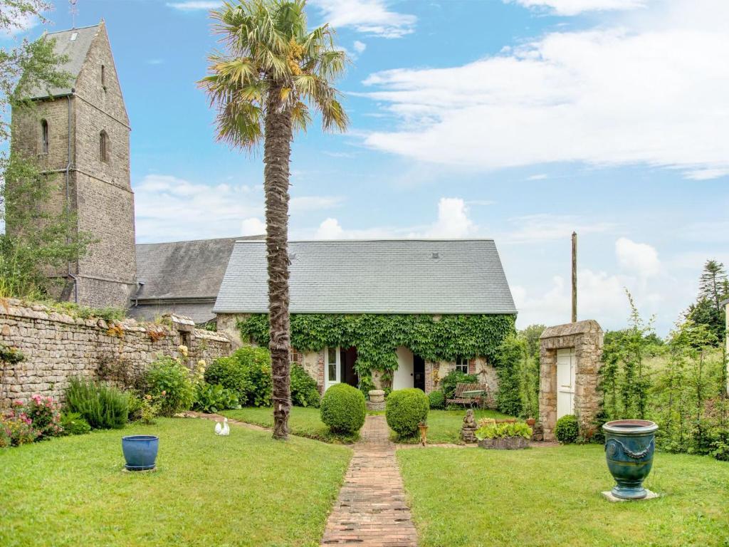 eine Palme vor einer Kirche in der Unterkunft Holiday home in Houtteville with garden in Picauville