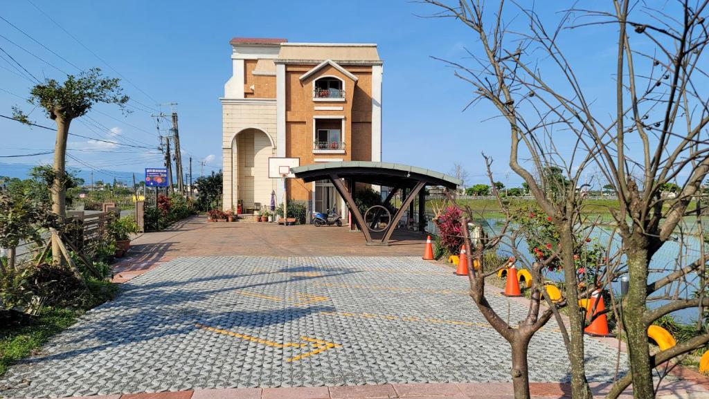 une passerelle en pierre à côté d'un bâtiment avec un toit noir dans l'établissement ChaoPingJia Homestay, à Luodong