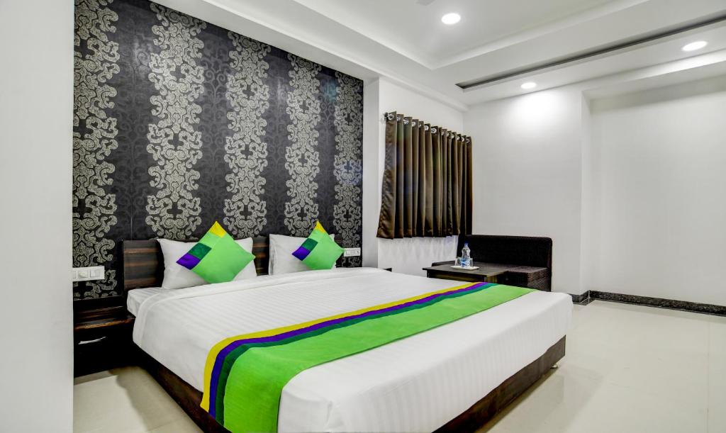 インドールにあるTreebo Trend Grand Euro Pipliyahana Squareのベッドルーム(白い大型ベッド、緑の毛布付)