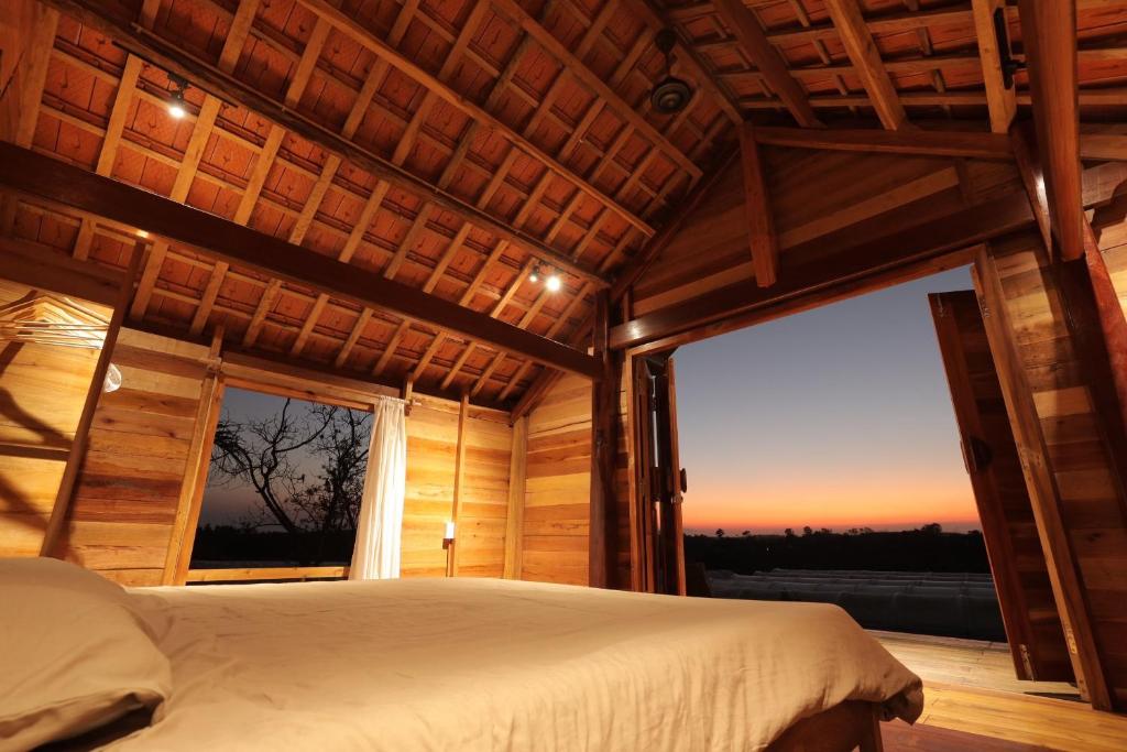 sypialnia z łóżkiem i dużym oknem w obiekcie TODO Farm - Organic Farming & Retreat w mieście Phu Yen