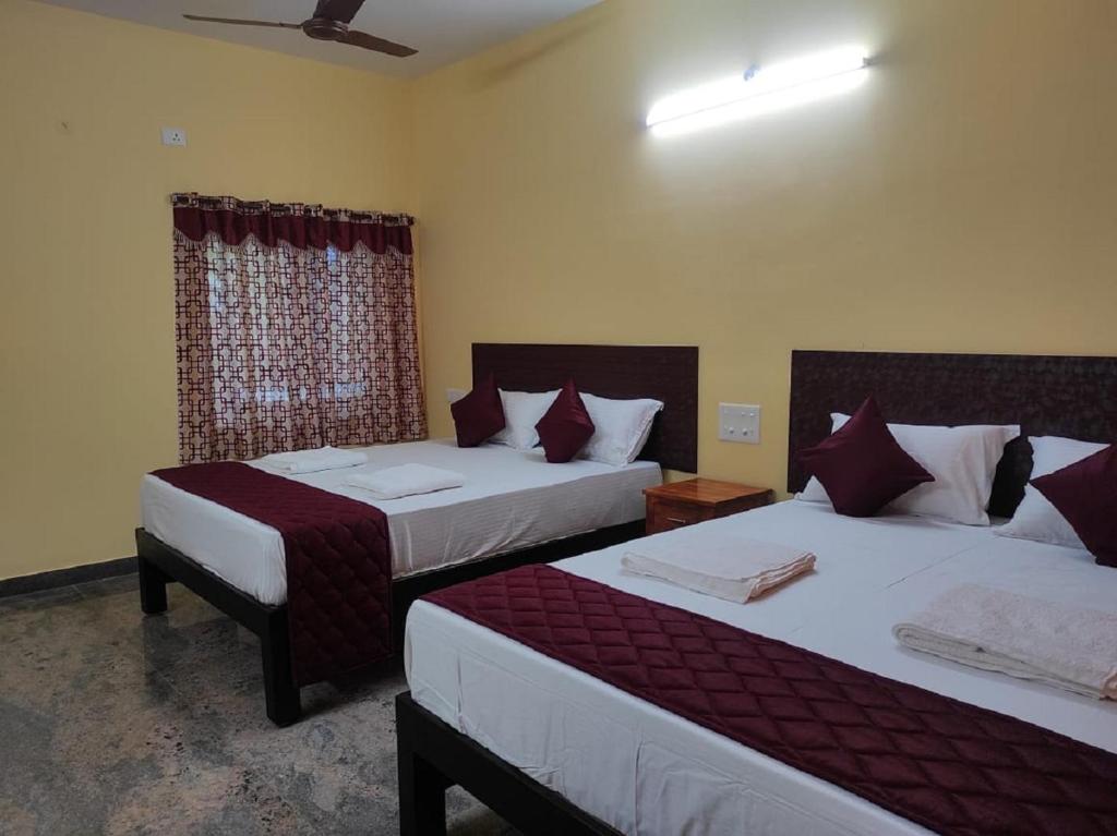 una camera d'albergo con due letti e una finestra di Le Springlynn Residency a Pondicherry