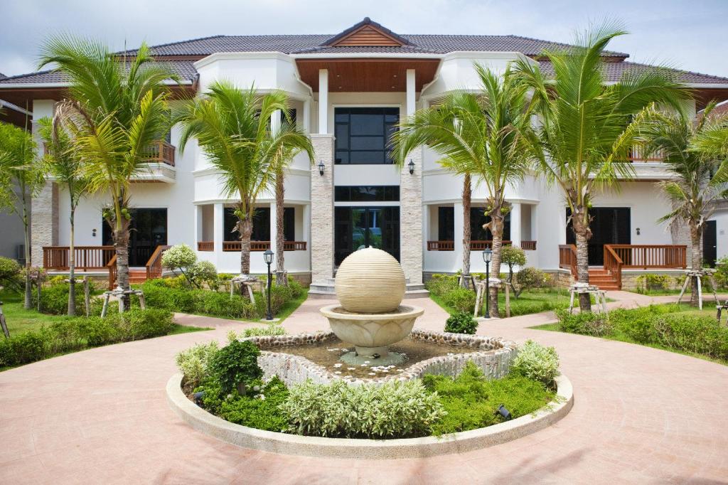 a building with a fountain in front of a building at Rawai Grand House -SHA Plus in Rawai Beach