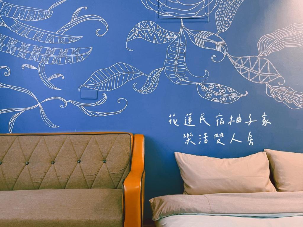 a bedroom with a blue wall with drawings on it at Yuzi Homestay in Hualien City