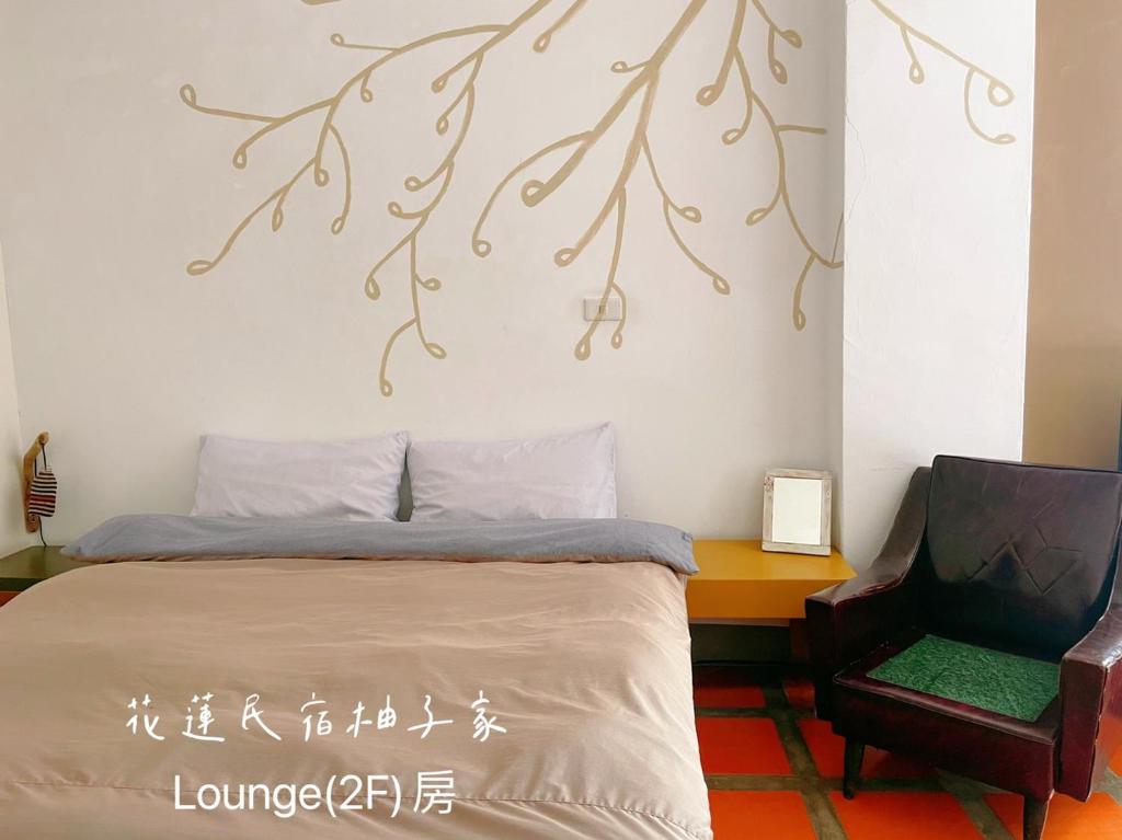 a bedroom with a bed and a chair at Yuzi Homestay in Hualien City