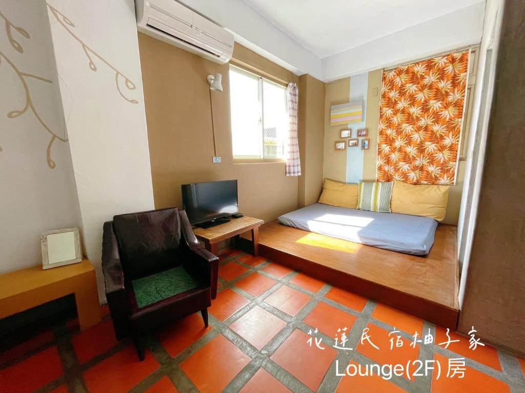 a small room with a bed and a chair at Yuzi Homestay in Hualien City