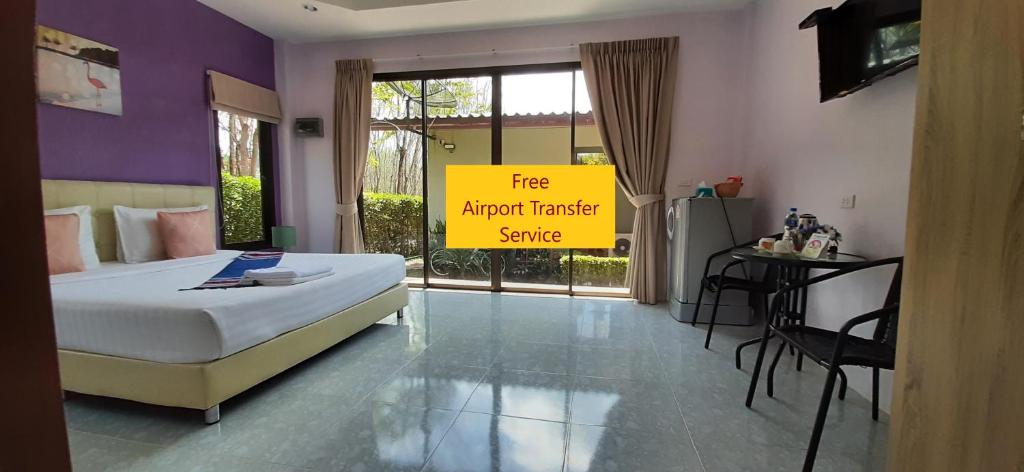 um quarto com uma cama e uma placa que lê o serviço de transporte gratuito de/para o aeroporto em Phuket Sirinapha Resort em Praia de Nai Yang