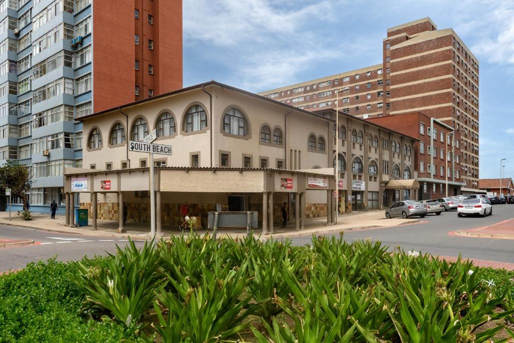 a building on the corner of a street with buildings at Ushaka Holiday Apartments in Durban
