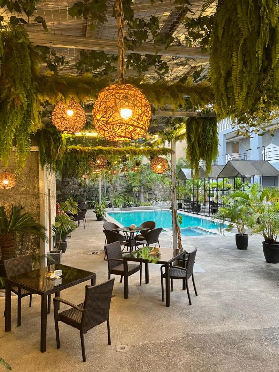 un patio con mesas y sillas y una piscina en Hotel Halo, en Ángeles
