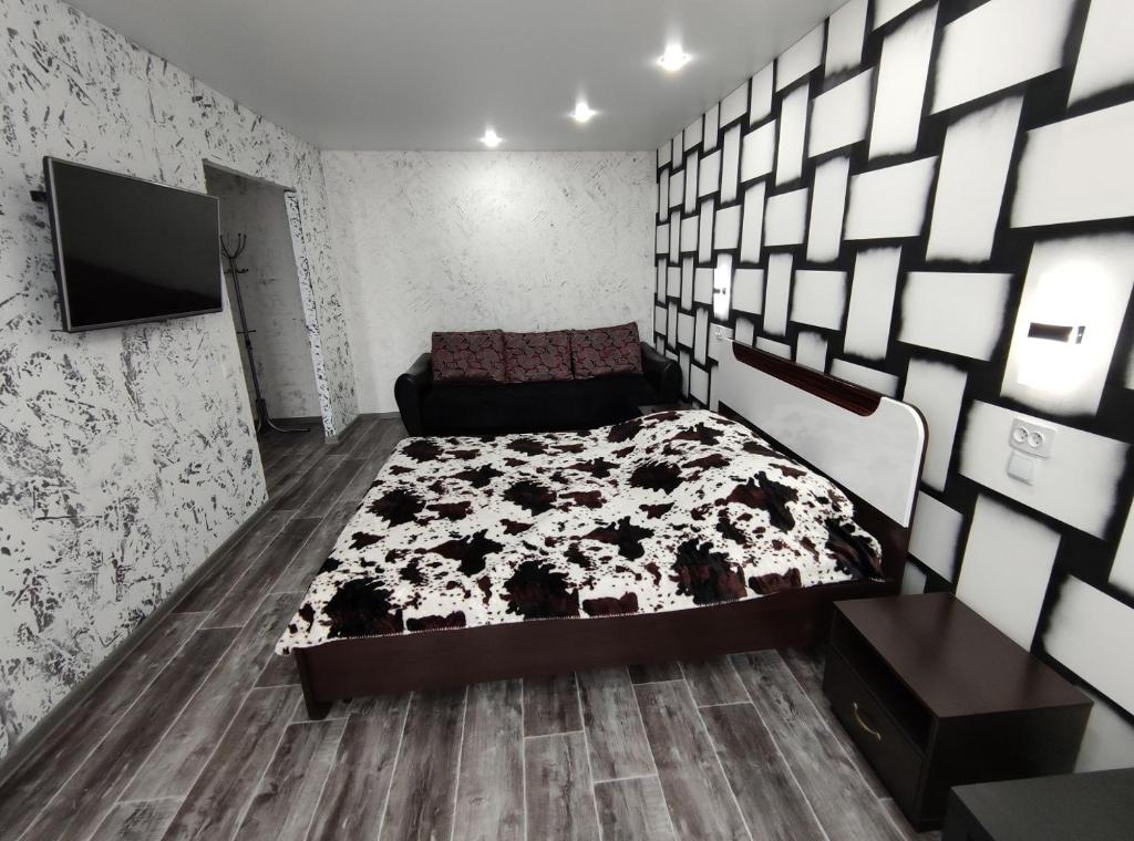 TuymazyにあるSutki 700 Komarova 28のベッドルーム1室(ベッド1台、白黒の掛け布団付)