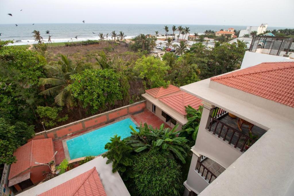 an aerial view of a house with a swimming pool and the beach at Costa Verde Luxury Seafront Villa in Chennai