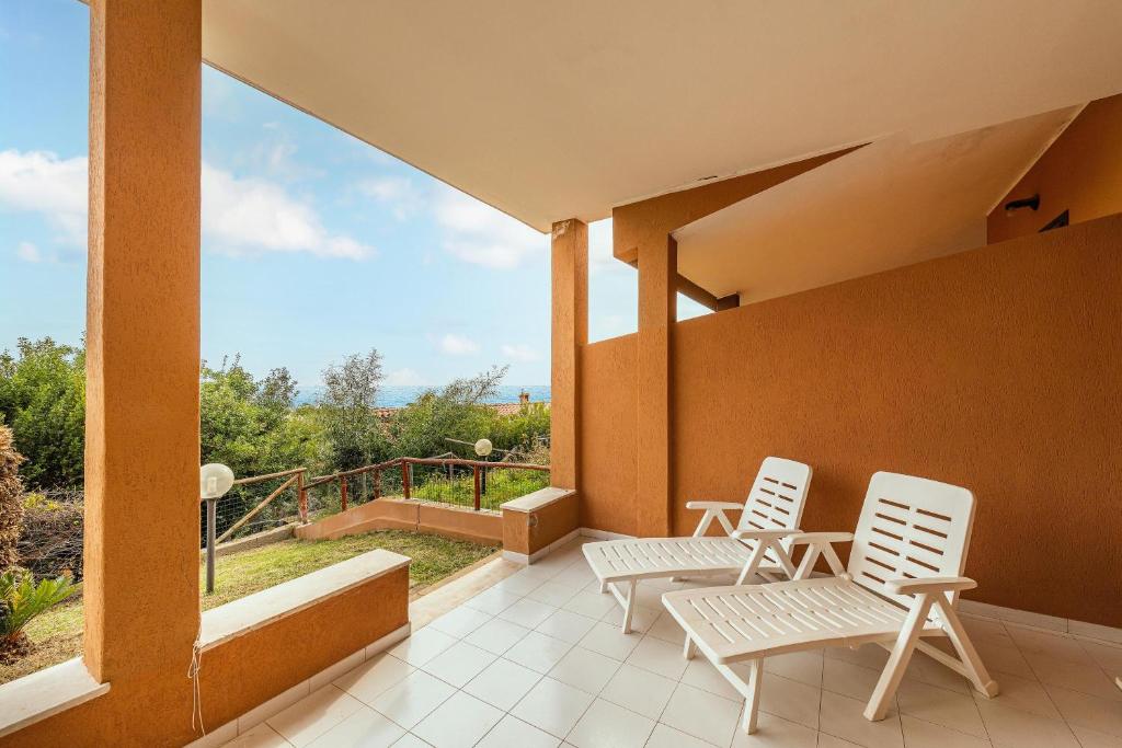 two chairs sitting on a balcony with a view at Casa delle Poiane Costa Rei in Monte Nai