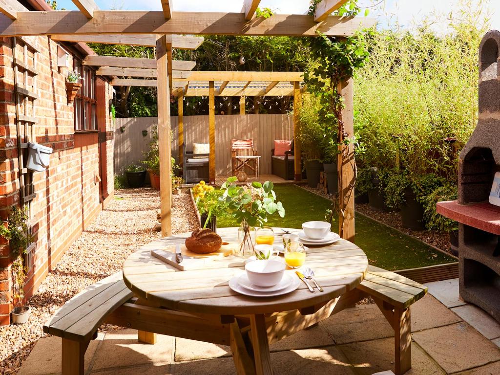 a wooden table in the middle of a garden at Rosewood Cottage in Bridlington
