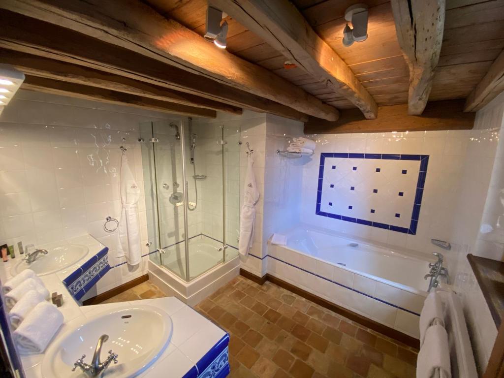 ein Badezimmer mit 2 Waschbecken, einer Dusche und einer Badewanne in der Unterkunft Le Hameau de Barboron in Savigny-lès-Beaune