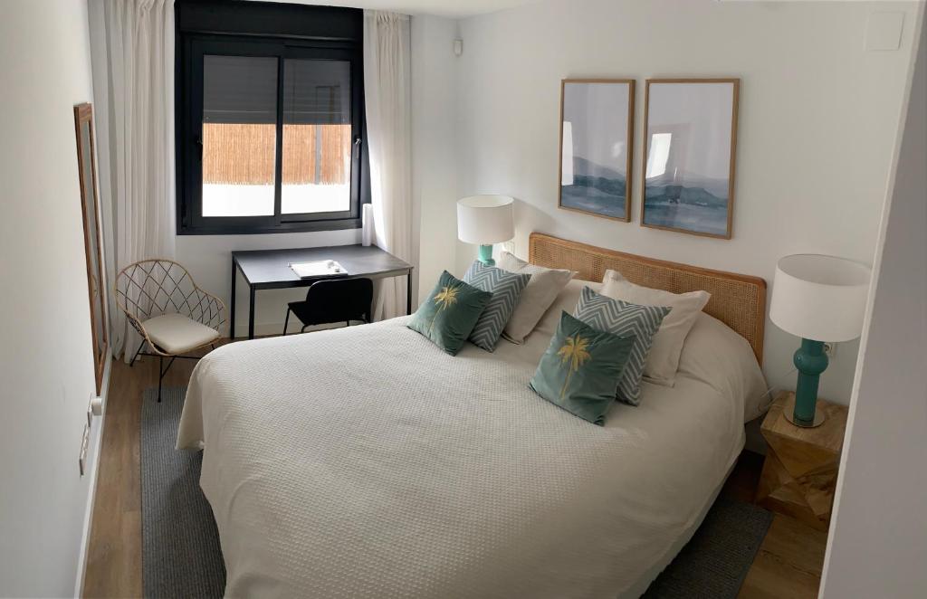 Un dormitorio con una cama blanca con almohadas y una ventana en TERRAZAS DEL MAR with POOL en Torremolinos
