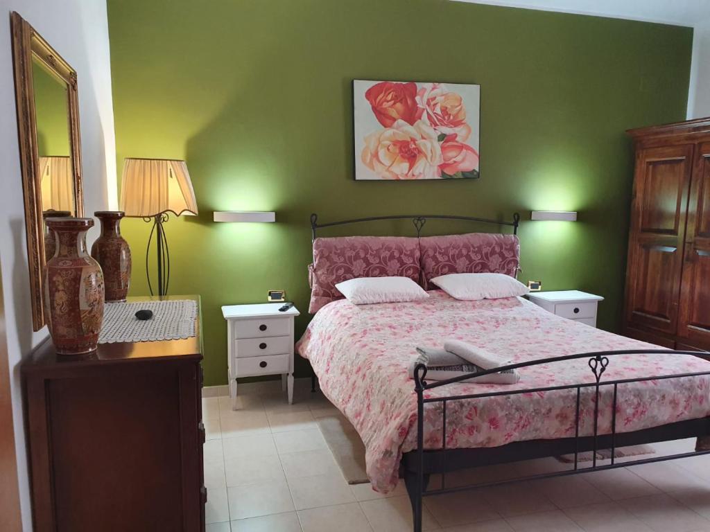 ein Schlafzimmer mit einem Bett und einer grünen Wand in der Unterkunft Casamia - 2 camere da letto in Alba Adriatica