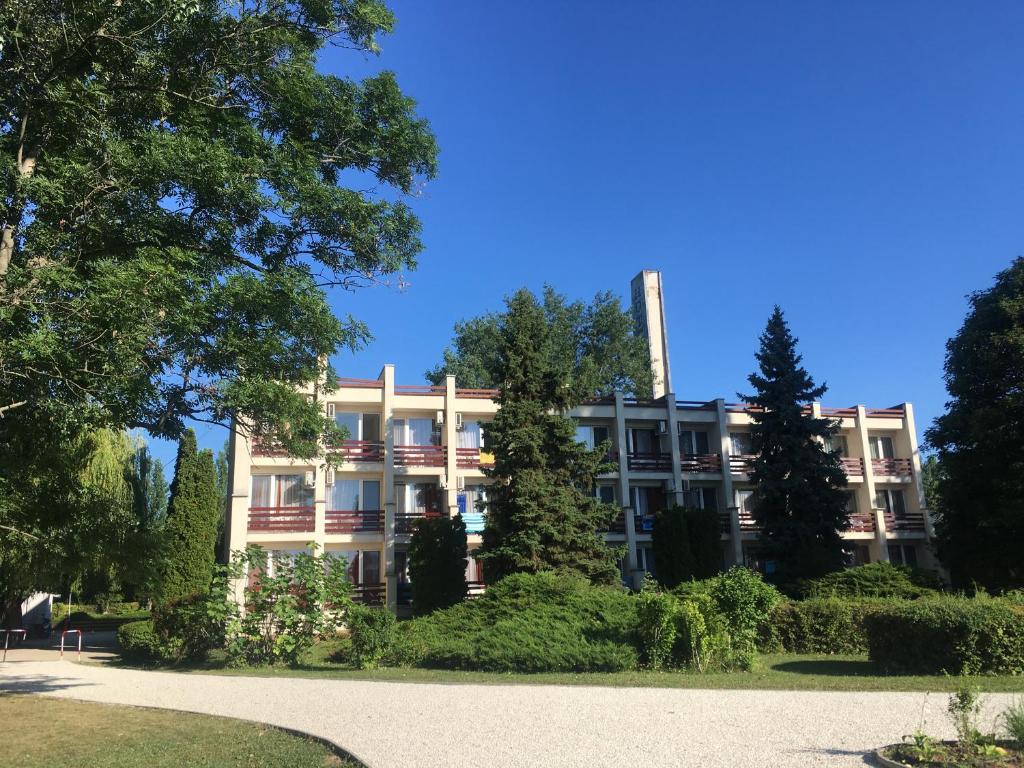 an apartment building in the middle of a park at Nereus Park Hotel in Balatonalmádi