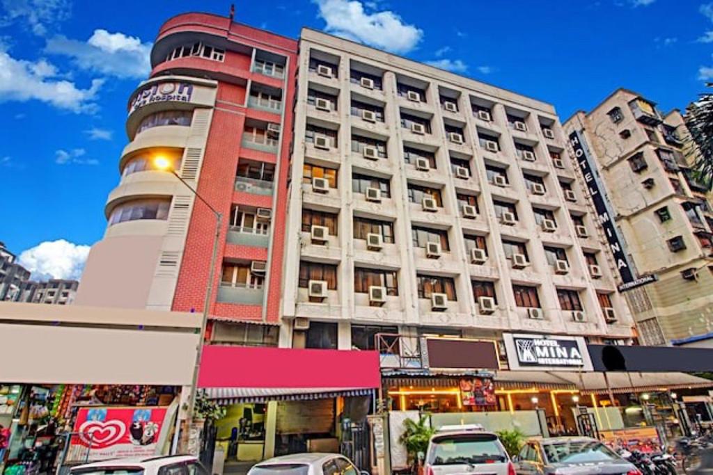 un edificio alto con coches estacionados frente a él en Hotel Mina International, en Bombay
