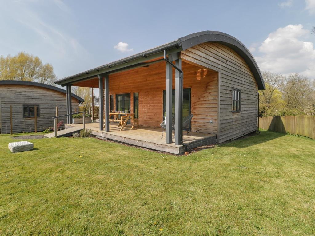 una piccola casa con un tetto di gamberetti su un cortile di Foxglove a Glastonbury