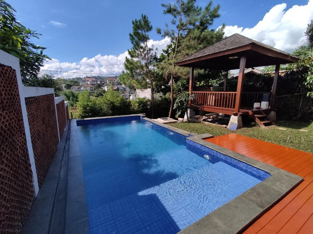 uma piscina num quintal com um gazebo em Villa Etnik Syariah em Bandung