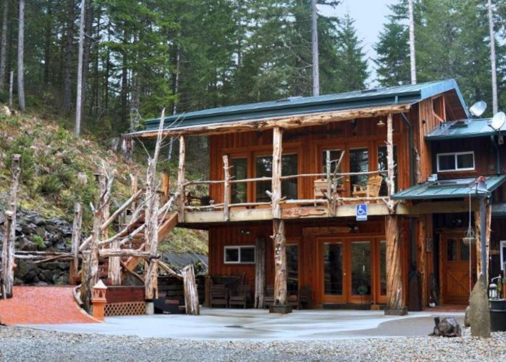 a log cabin in the woods with a balcony at LANZAROTTA Bed and Breakfast in Creswell