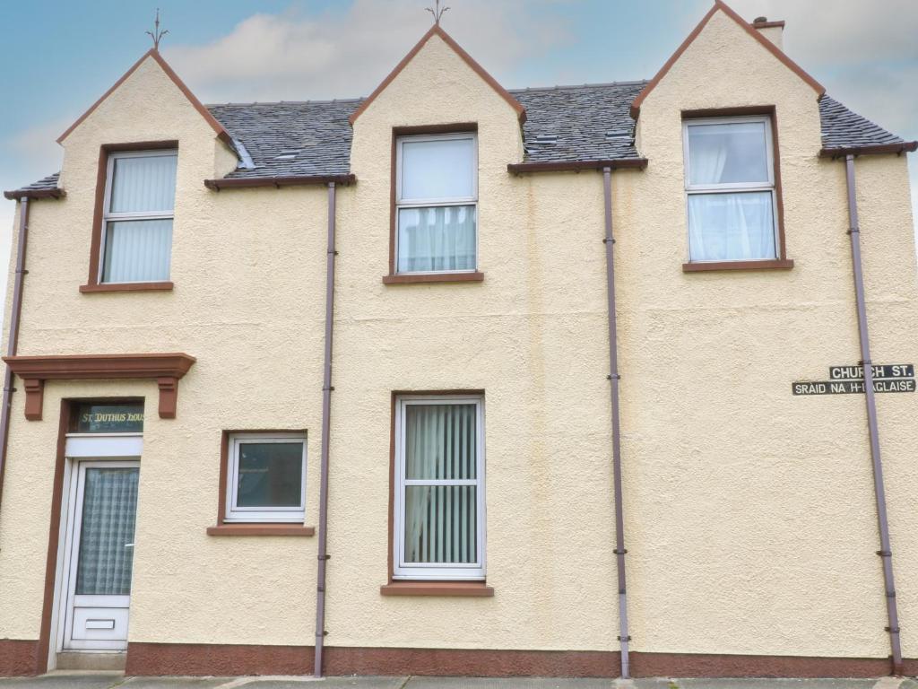 a brick house with a street sign in front of it at St Duthus House in Stornoway