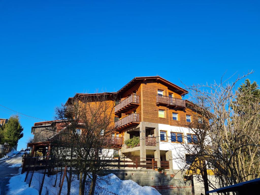 a large wooden building with balconies in the snow at Penzión Malá Fatra u Ďurka -Terchová in Žilina