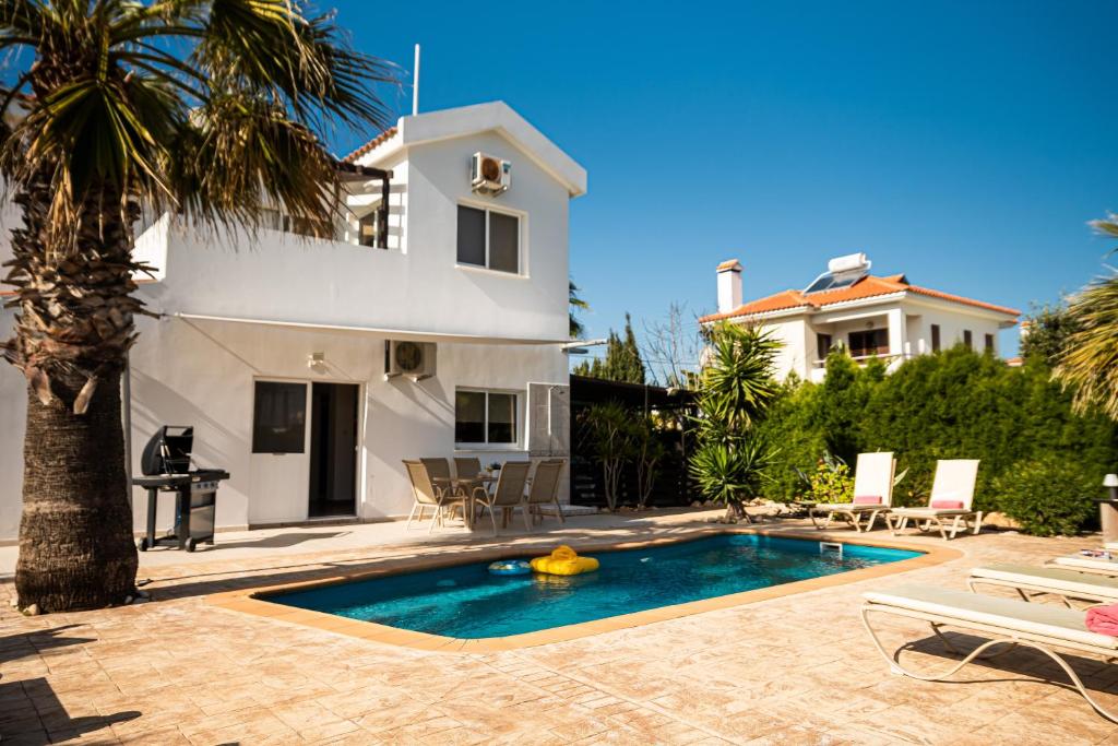 a villa with a swimming pool in front of a house at Protaras View Villas in Protaras