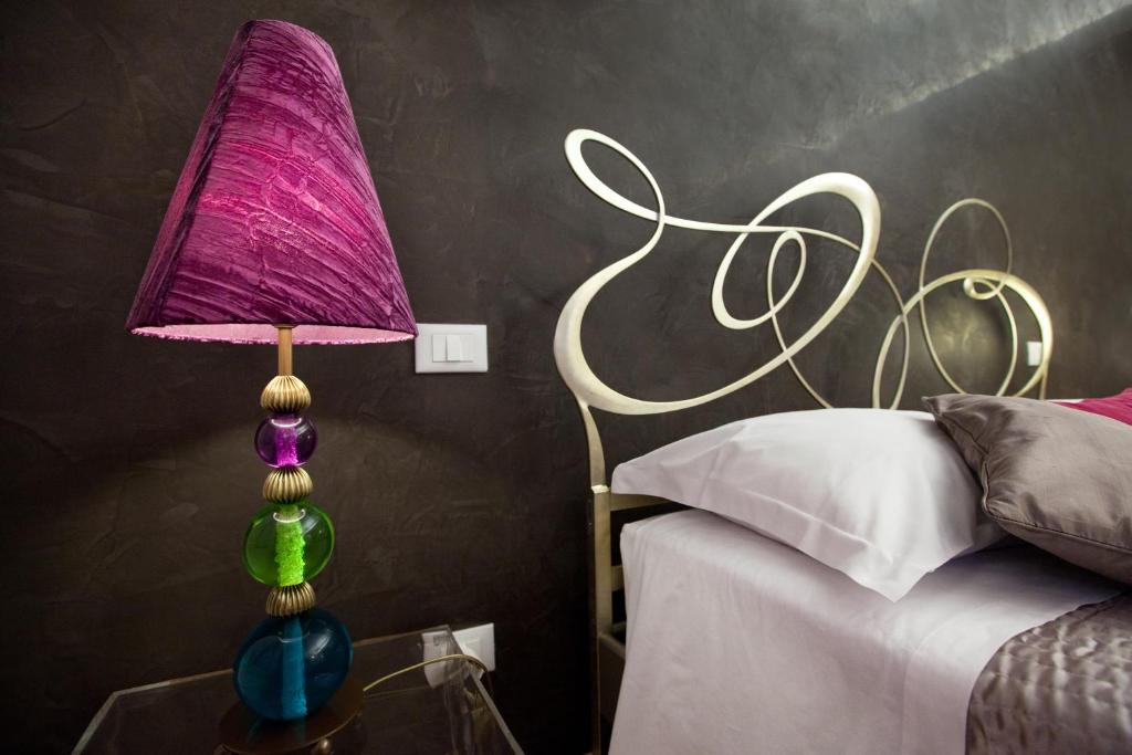 a purple lamp on a glass table next to a bed at Town House Fontana Di Trevi in Rome