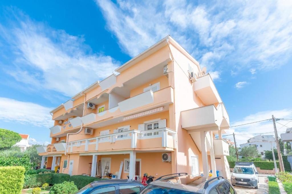 a building with cars parked in front of it at Apartments Niko in Novalja