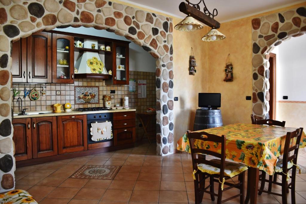 a kitchen with a table and a stone archway at Appartamento Girasole in Santa Domenica