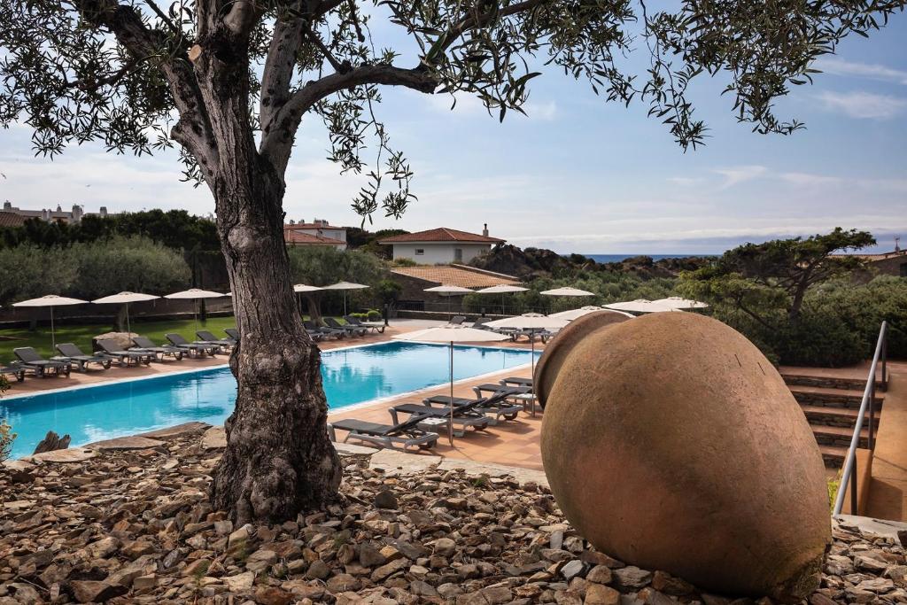 
a large rock sitting on top of a sandy beach at Hotel Sol Ixent in Cadaqués
