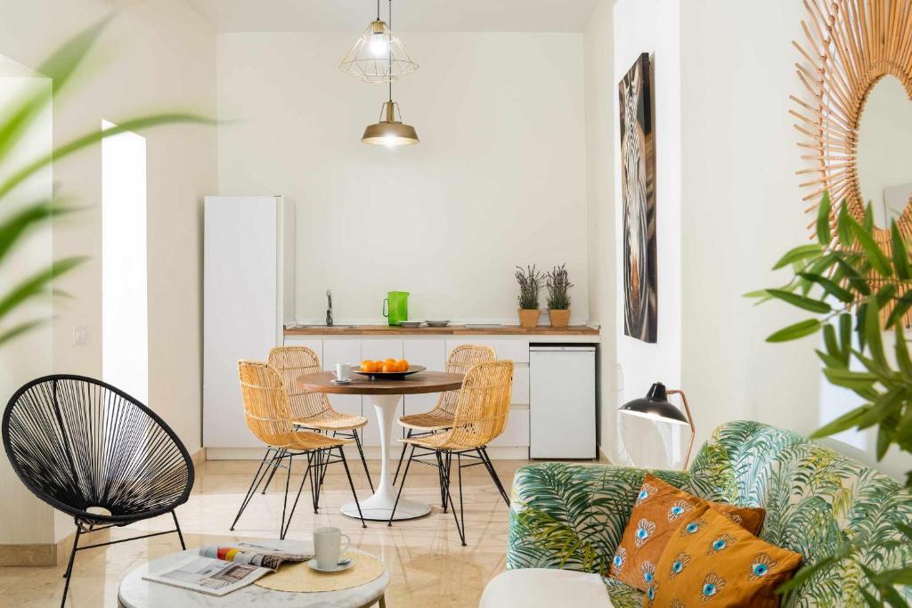 salon z kanapą i stołem z krzesłami w obiekcie MonKeys Apartments Loft Pureza w Sewilli