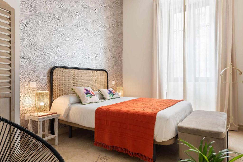 mała sypialnia z łóżkiem i oknem w obiekcie MonKeys Apartments Loft Pureza w Sewilli
