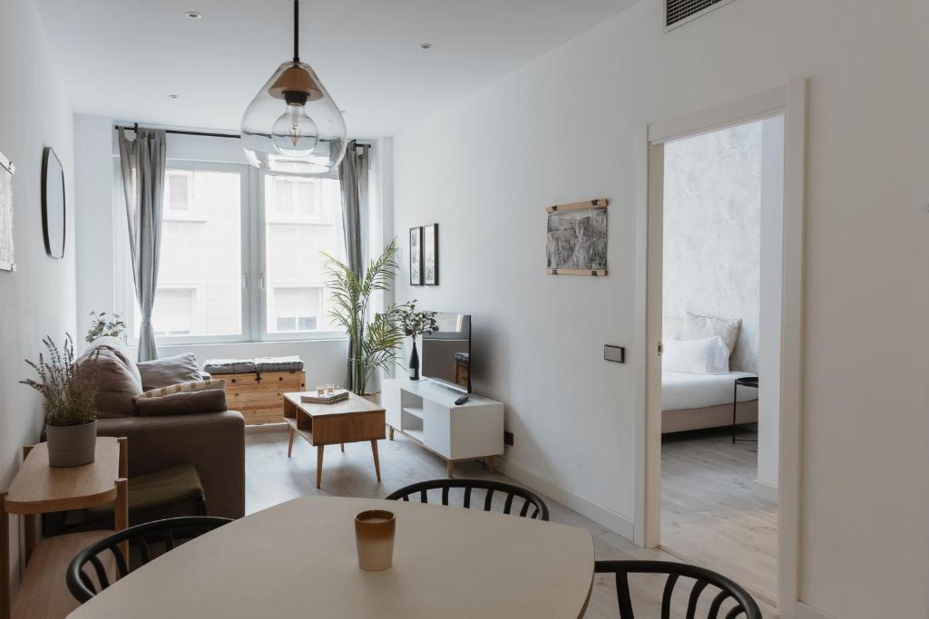 ein Wohnzimmer mit einem Tisch und einem Sofa in der Unterkunft Apartamentos Progres in Hospitalet de Llobregat