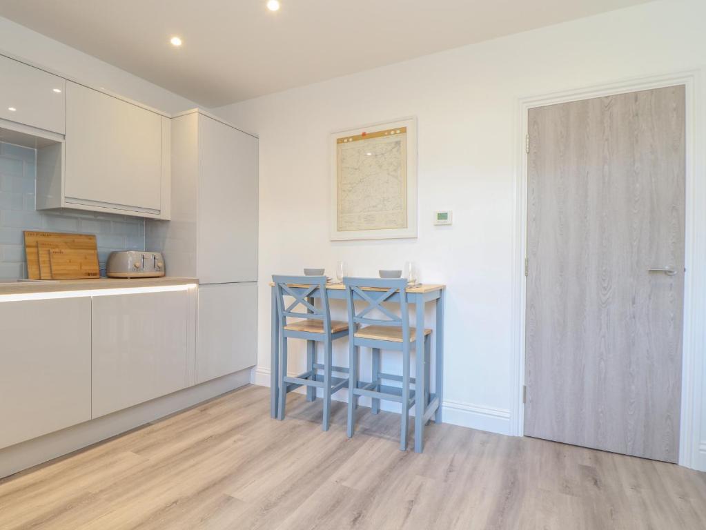 a kitchen with a blue stool in a room at Mews House in Camborne