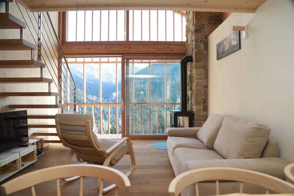 a living room with a couch and chairs and a large window at Villa Alpina Campiglio in Madonna di Campiglio